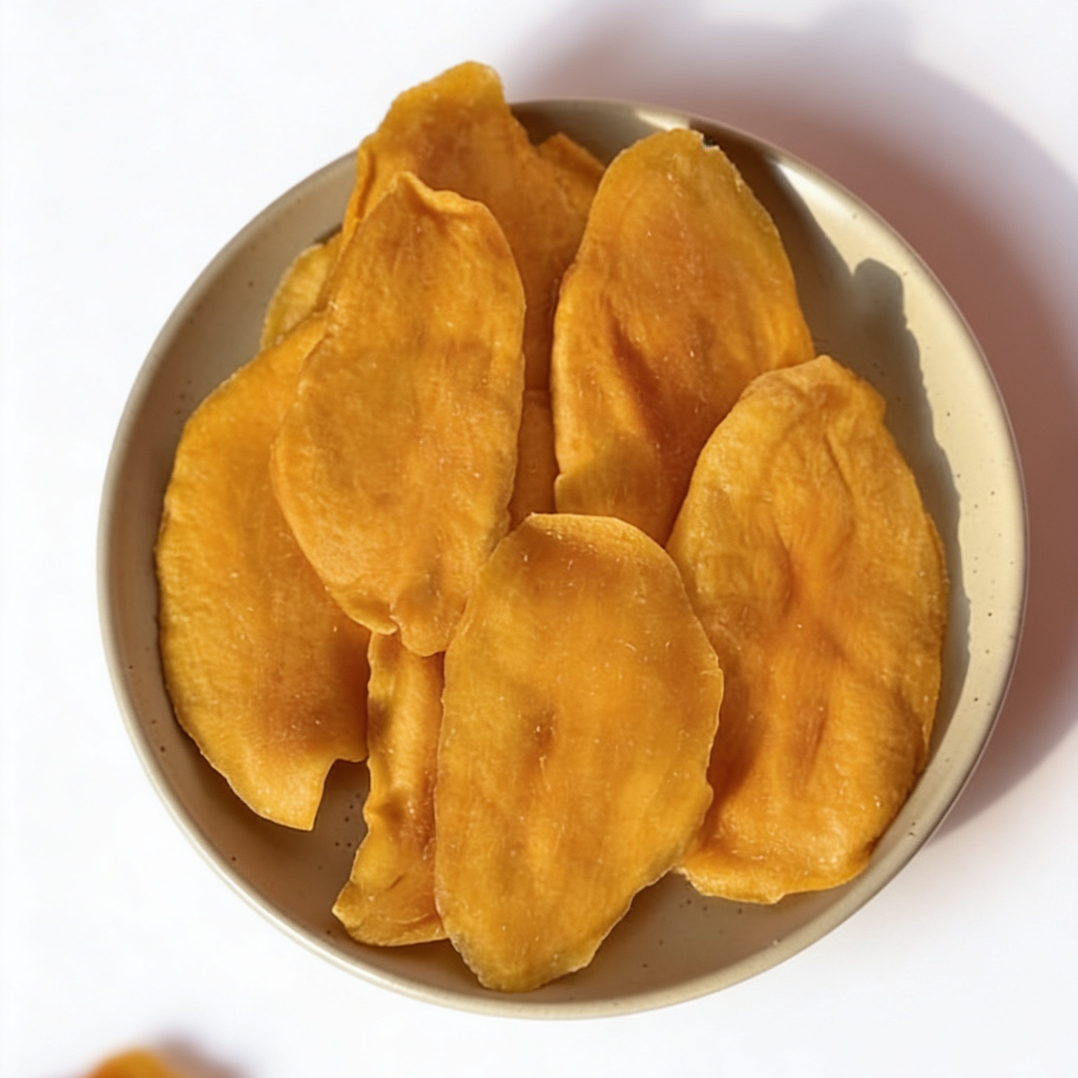 Dried mango on a white plate with a white background