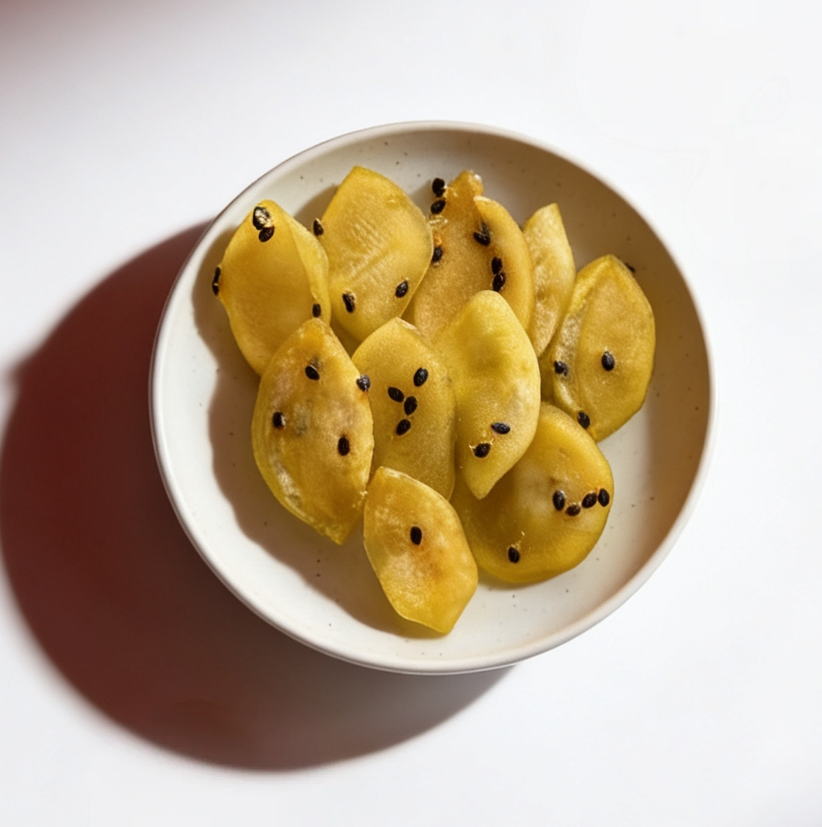 White bowl filled with dried passion fruit on a white background